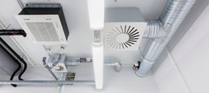 High-efficiency HVAC system components including ceiling-mounted air conditioning unit and ductwork, showcasing modern installation for energy savings.