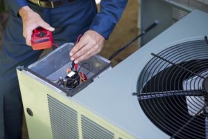 Technician performing maintenance on air conditioning unit, checking electrical components with multimeter, emphasizing professional HVAC service.