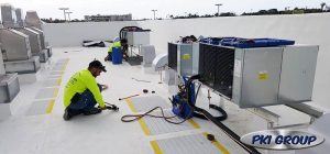 Technicians performing commercial refrigeration maintenance on rooftop units in Pensacola, Florida, showcasing Diamond Air Design's HVAC services.