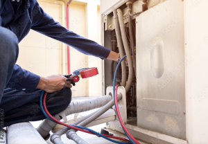 Technician performing HVAC maintenance on air conditioning unit, showcasing tools and equipment for service and repair.