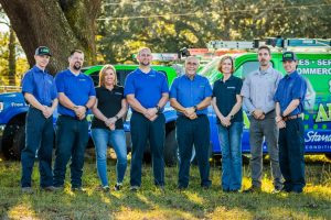 Diamond Air Design team members standing outdoors in front of branded service vehicles, showcasing professionalism and commitment to HVAC services.