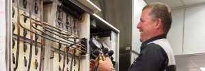 Technician servicing commercial refrigeration equipment in a professional kitchen setting.